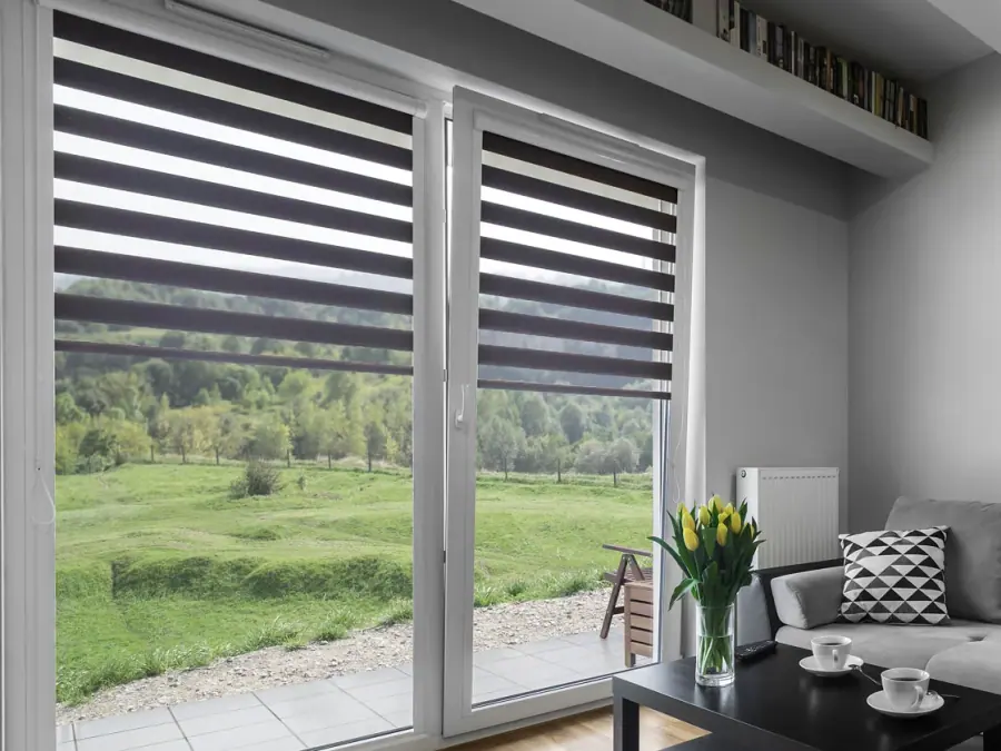 Sala con cortinas roller duo junto a un sofá gris